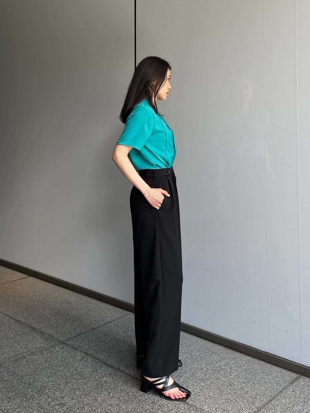 グリーン系のシャツ/ブラウス、ブラック系のスラックスを着用したレディースの夏コーディネートの2枚目の写真