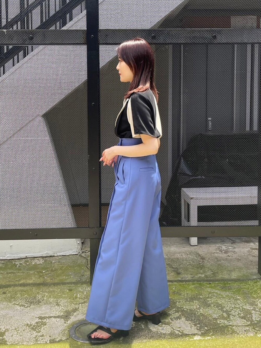 ベージュ系のシャツ/ブラウス、ブルー系のスラックスを着用したレディースの春コーディネートの4枚目の写真