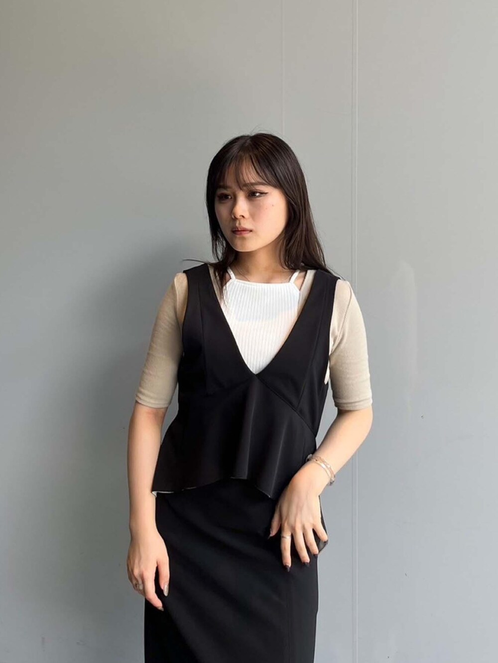 ベージュ系のTシャツ/カットソー、ブラック系のジャンパースカートを着用したレディースの夏コーディネートの3枚目の写真