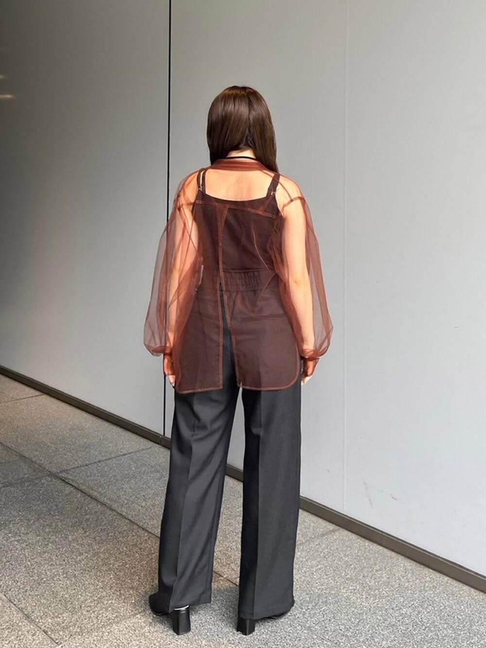 ブラウン系のシャツ/ブラウス、ブラック系のスラックスを着用したレディースの夏コーディネートの2枚目の写真