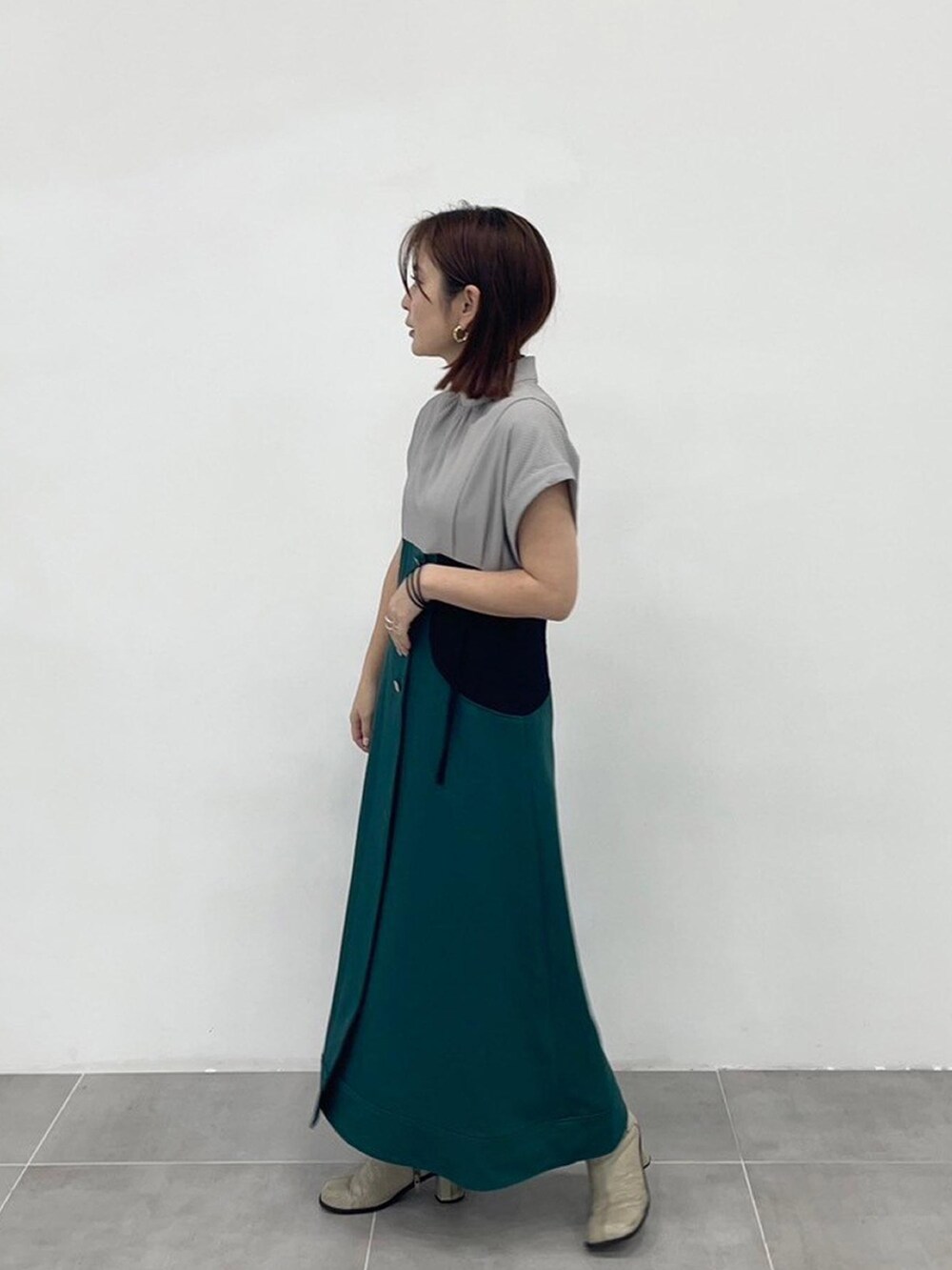 グリーン系のワンピースを着用したレディースの春コーディネートの2枚目の写真