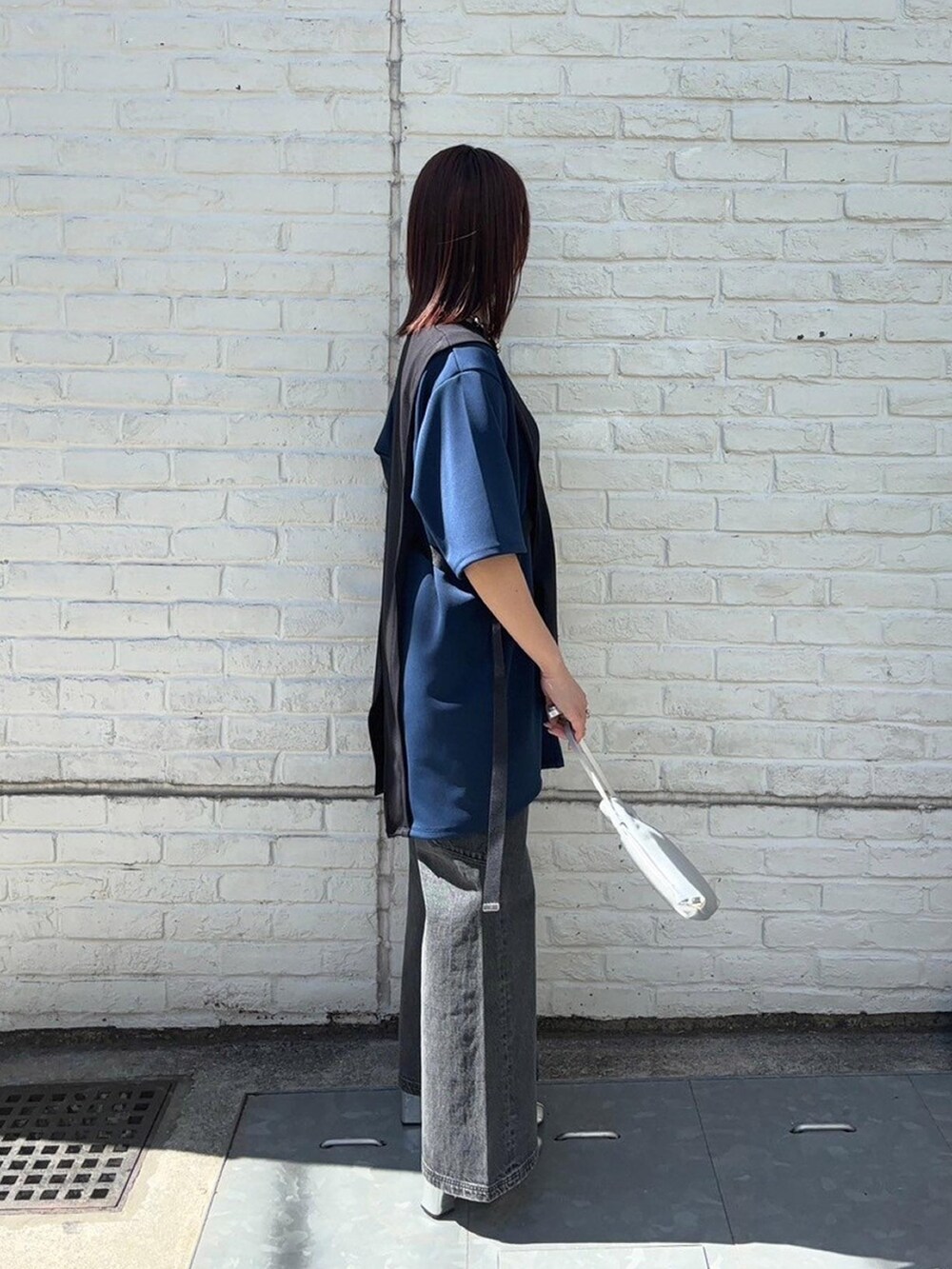 ブラック系のTシャツ/カットソー、ブラック系のデニムパンツを着用したレディースの春コーディネートの4枚目の写真