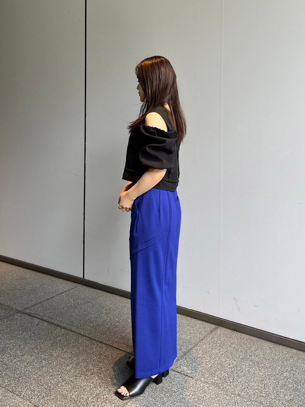 ブラック系のシャツ/ブラウス、ブルー系のスカートを着用したレディースの夏コーディネートの2枚目の写真