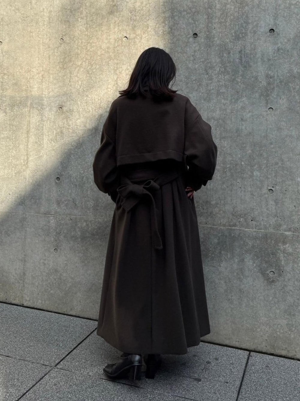 ブラウン系のステンカラーコートを着用したレディースの秋コーディネートの3枚目の写真