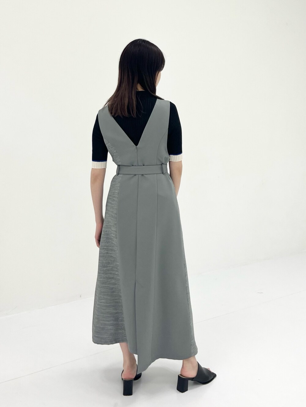 グレー系のジャンパースカート、ブラック系のニット/セーターを着用したレディースの夏コーディネートの4枚目の写真