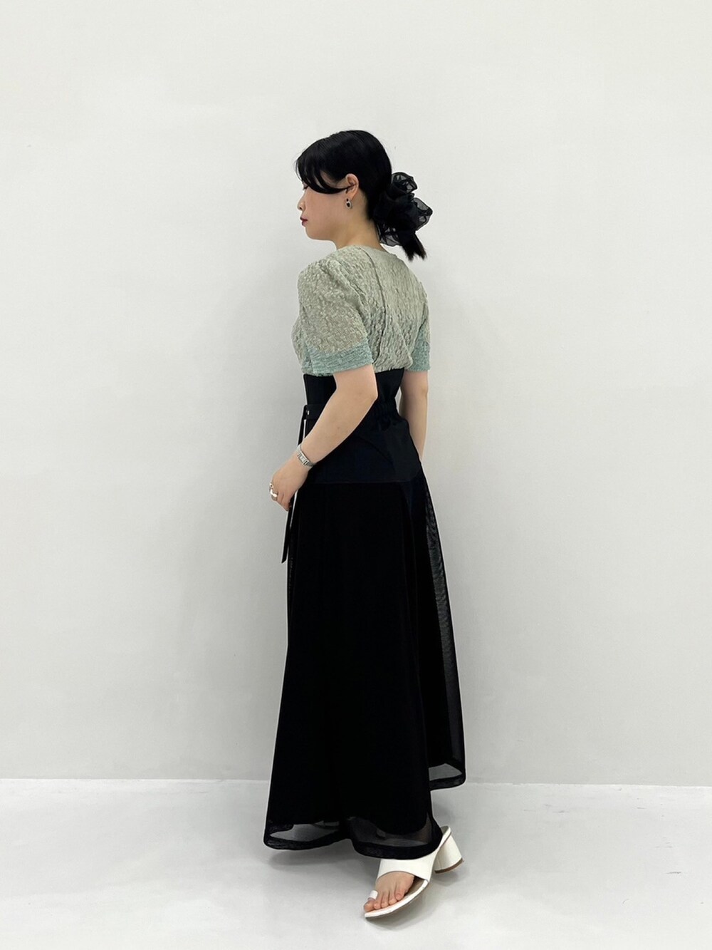 グリーン系のTシャツ/カットソー、ブラック系のスカートを着用したレディースの春コーディネートの3枚目の写真