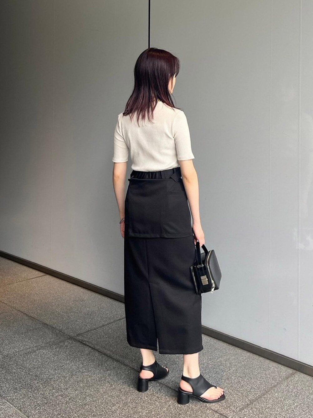 ホワイト系のTシャツ/カットソー、ブラック系のスカート、ブラック系のサンダルを着用したレディースの夏コーディネートの2枚目の写真