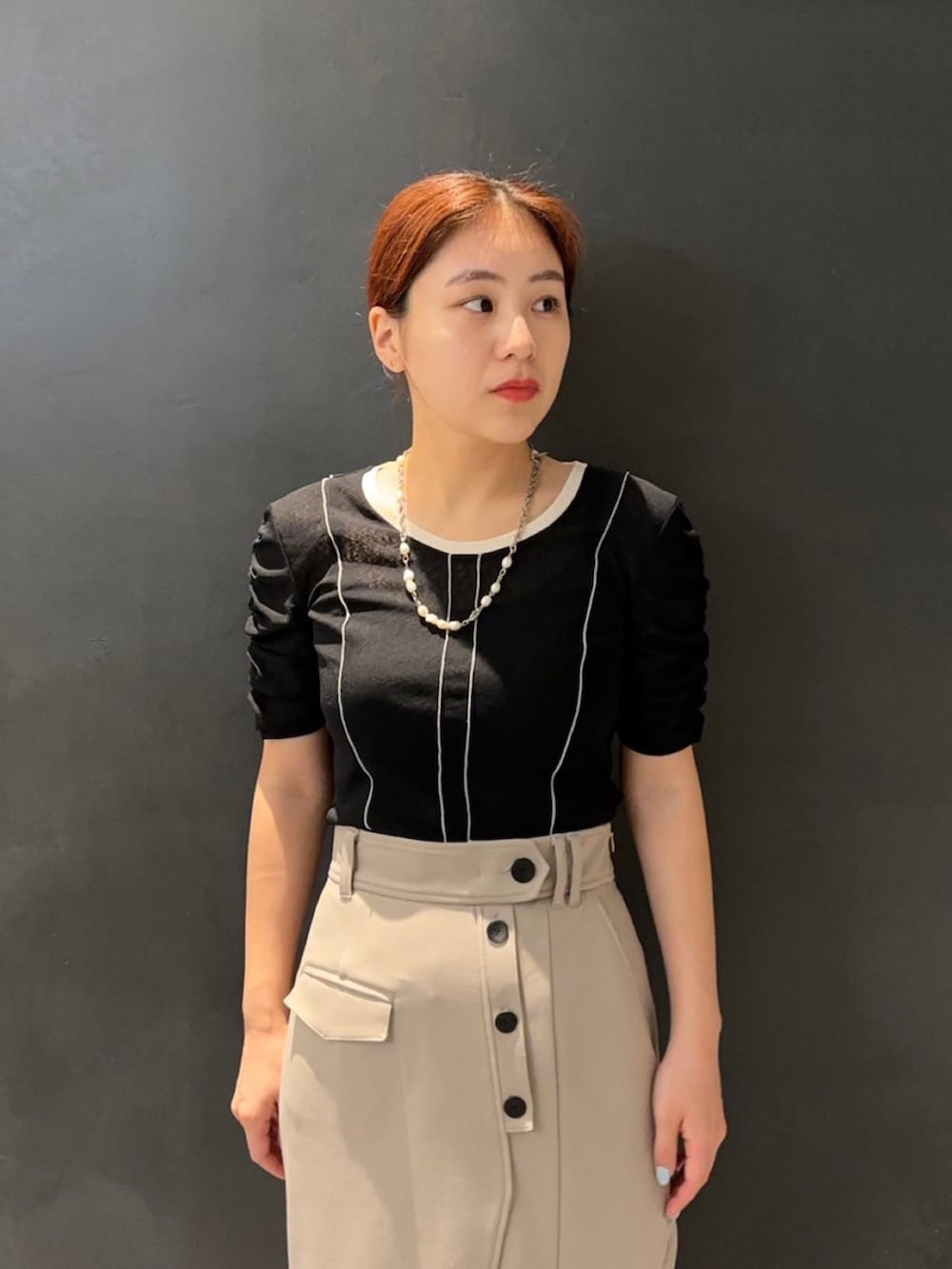 ブラック系のTシャツ/カットソー、ベージュ系のスカートを着用したレディースの夏コーディネートの4枚目の写真