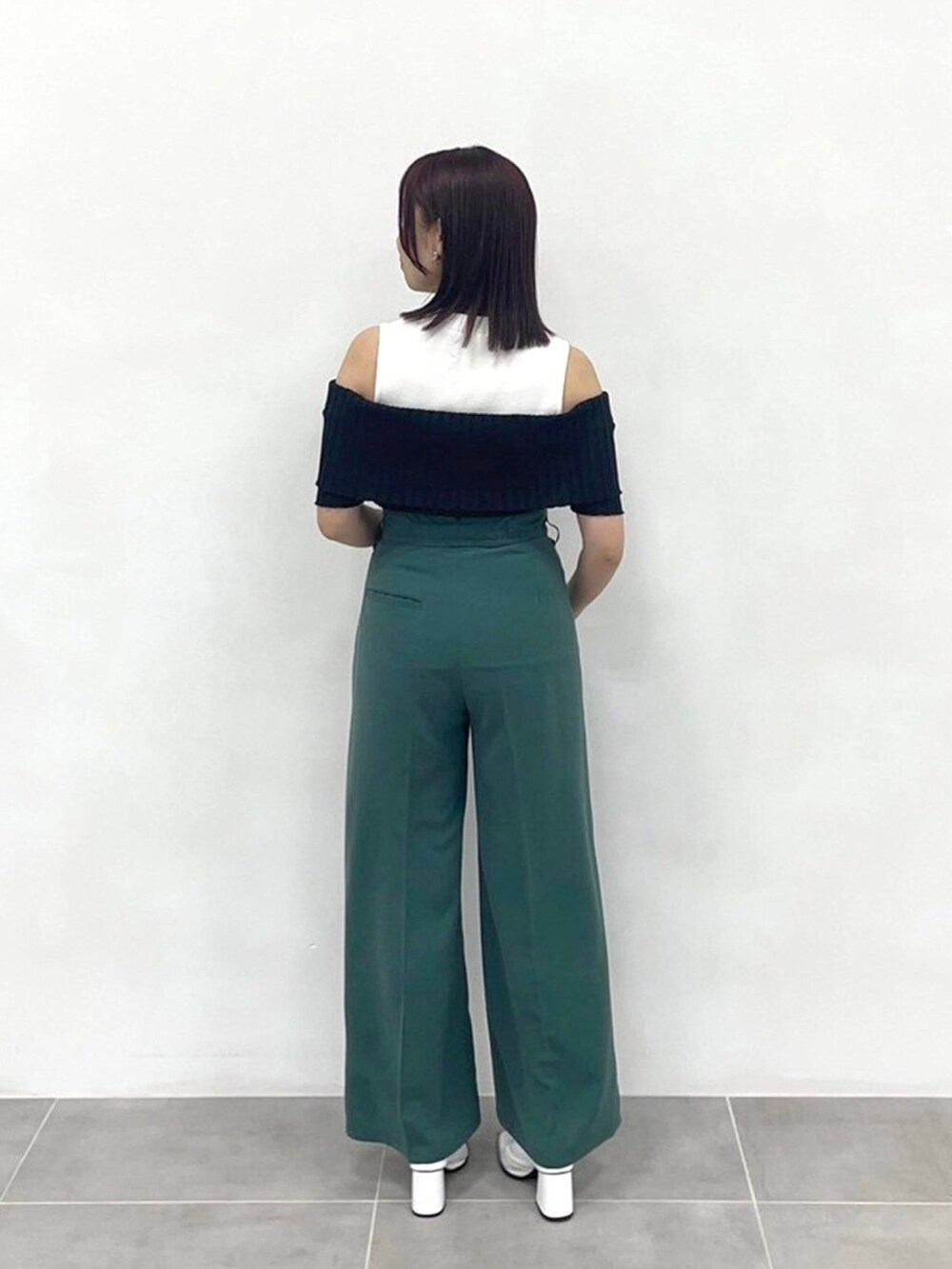 グリーン系のスラックス、ブラック系のニット/セーターを着用したレディースの春コーディネートの3枚目の写真