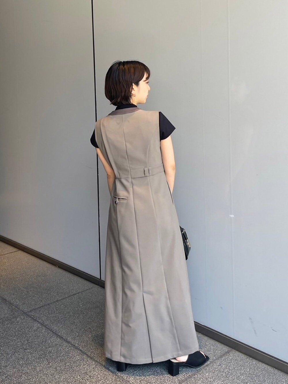 ブラック系のTシャツ/カットソー、ベージュ系のワンピースを着用したレディースの夏コーディネートの2枚目の写真