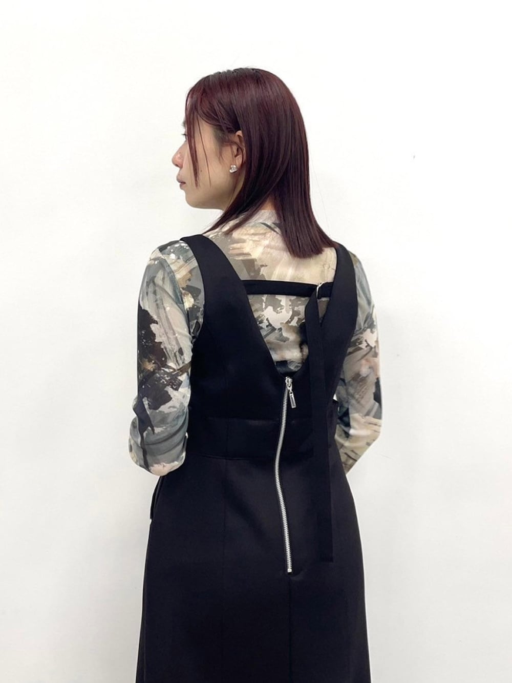 ブラック系のジャンパースカートを着用したレディースの春コーディネートの6枚目の写真