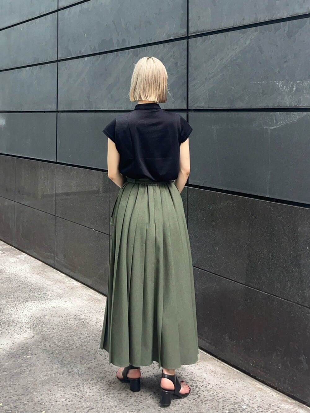 ブラック系のTシャツ/カットソー、グリーン系のスカートを着用したレディースの夏コーディネートの3枚目の写真