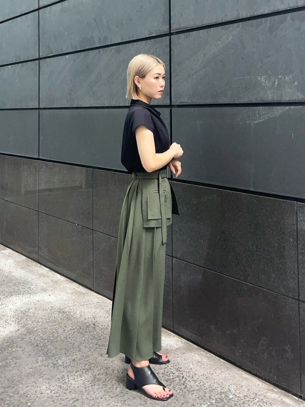 ブラック系のTシャツ/カットソー、グリーン系のスカートを着用したレディースの夏コーディネートの2枚目の写真