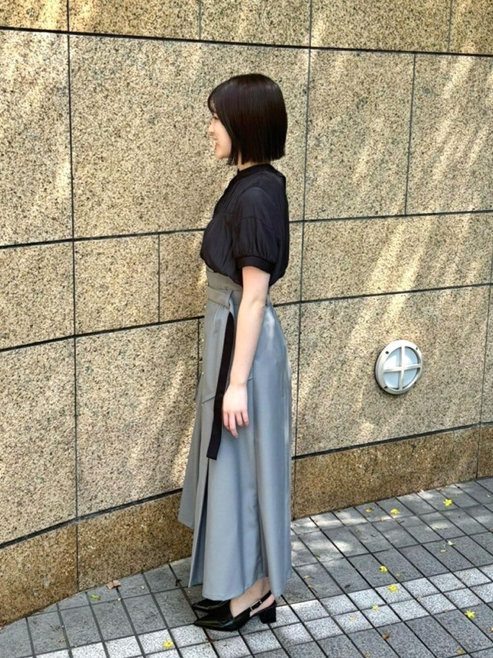 ブラック系のシャツ/ブラウス、グレー系のスカートを着用したレディースの春コーディネートの2枚目の写真