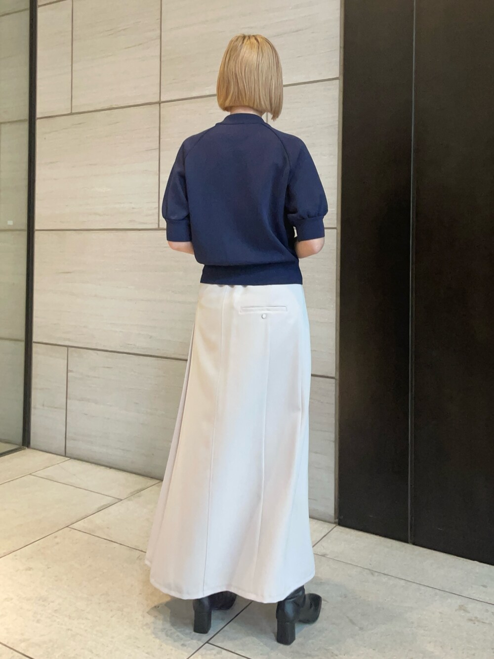 ブルー系のニット/セーター、ベージュ系のスカートを着用したレディースの春コーディネートの3枚目の写真