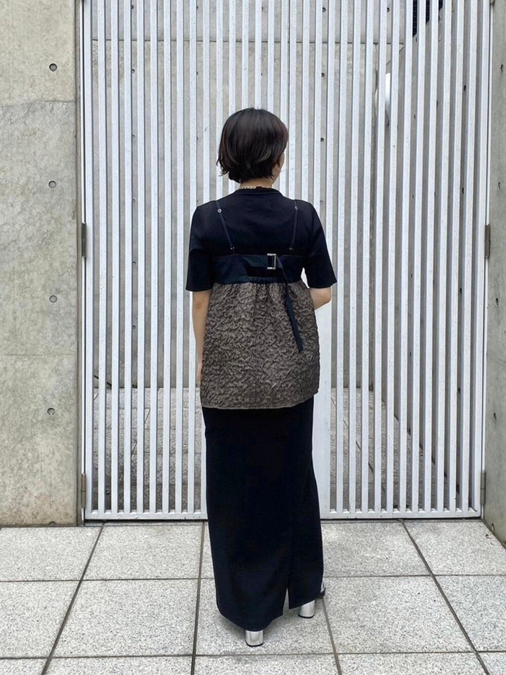 グリーン系のキャミソールを着用したレディースの春コーディネートの3枚目の写真