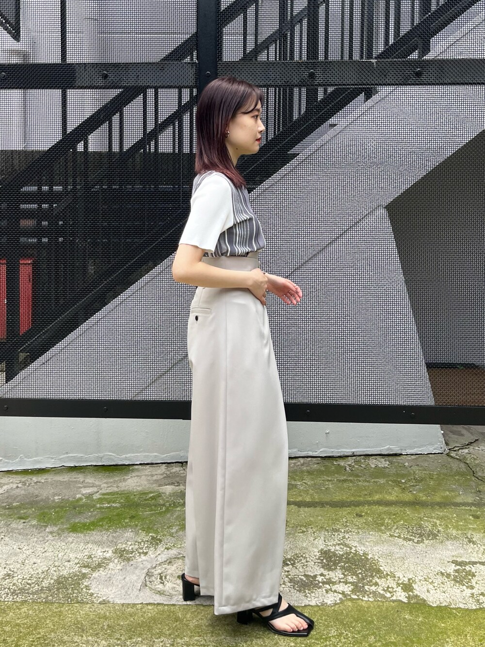 イエロー系のニット/セーター、グレー系のスラックスを着用したレディースの春コーディネートの3枚目の写真