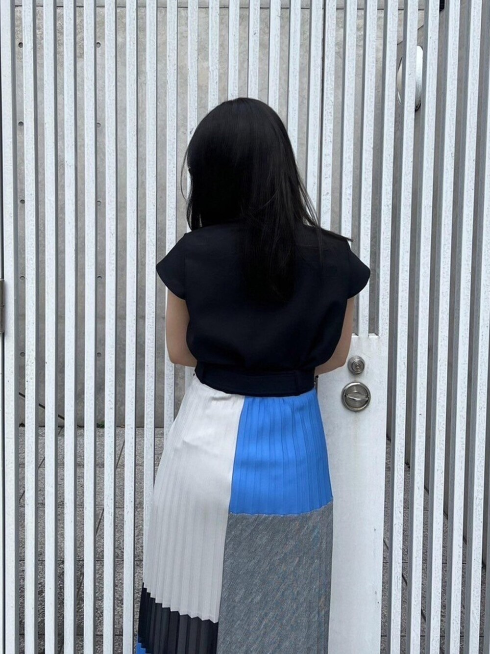 ブラック系のシャツ/ブラウス、ブルー系のスカートを着用したレディースの春コーディネートの6枚目の写真