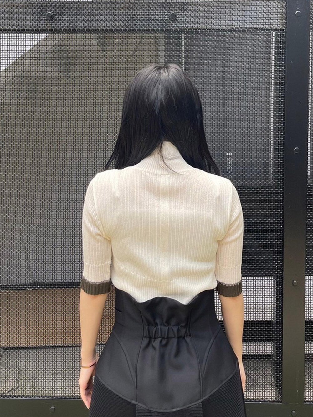 ブラック系のスカート、ホワイト系のニット/セーターを着用したレディースの春コーディネートの5枚目の写真