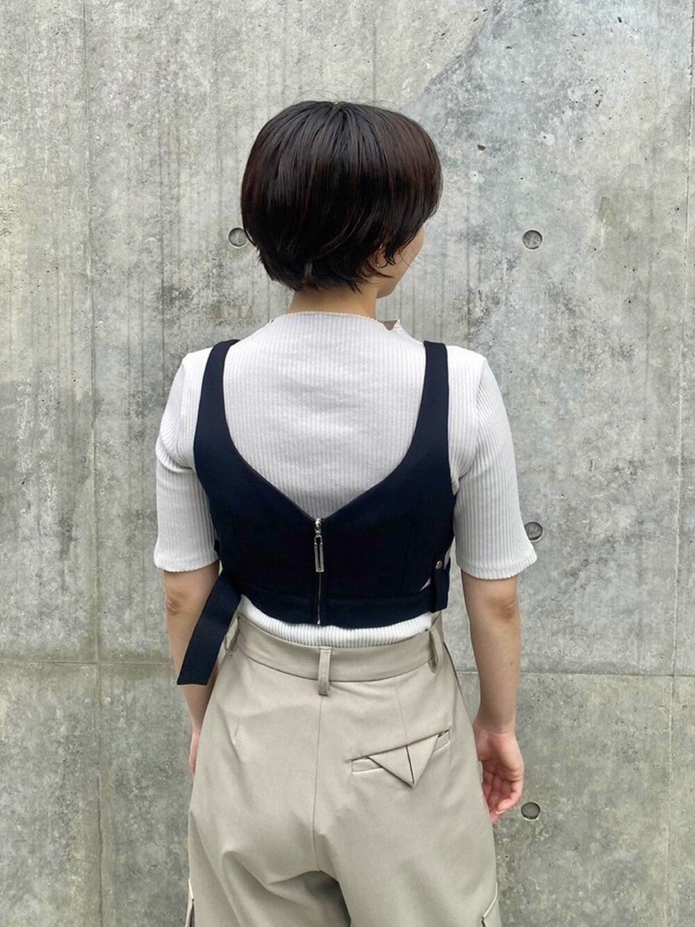 ホワイト系のTシャツ/カットソー、ブラック系のベストを着用したレディースの春コーディネートの6枚目の写真