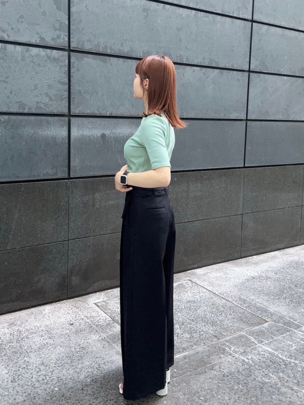 グリーン系のTシャツ/カットソー、ブラック系のスラックスを着用したレディースの夏コーディネートの2枚目の写真