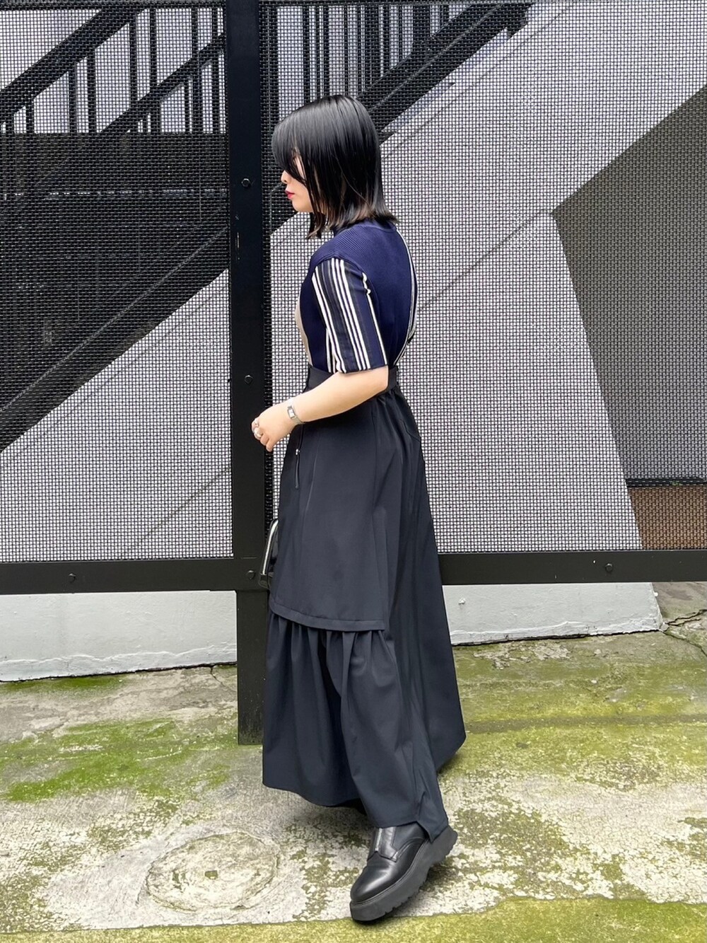 ブルー系のニット/セーター、ブラック系のスカートを着用したレディースの春コーディネートの2枚目の写真