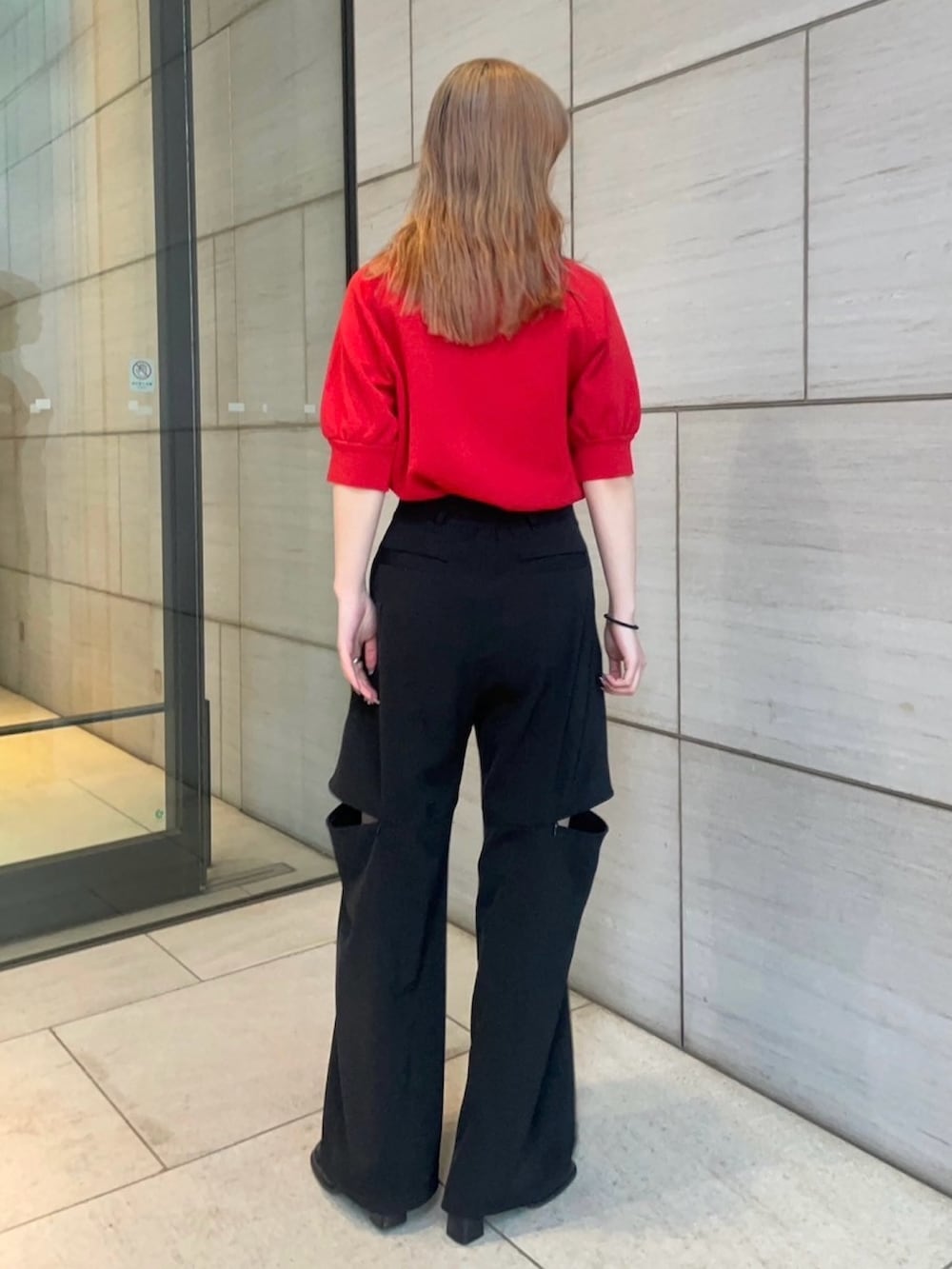 レッド系のニット/セーター、ブラック系のその他パンツを着用したレディースの春コーディネートの3枚目の写真