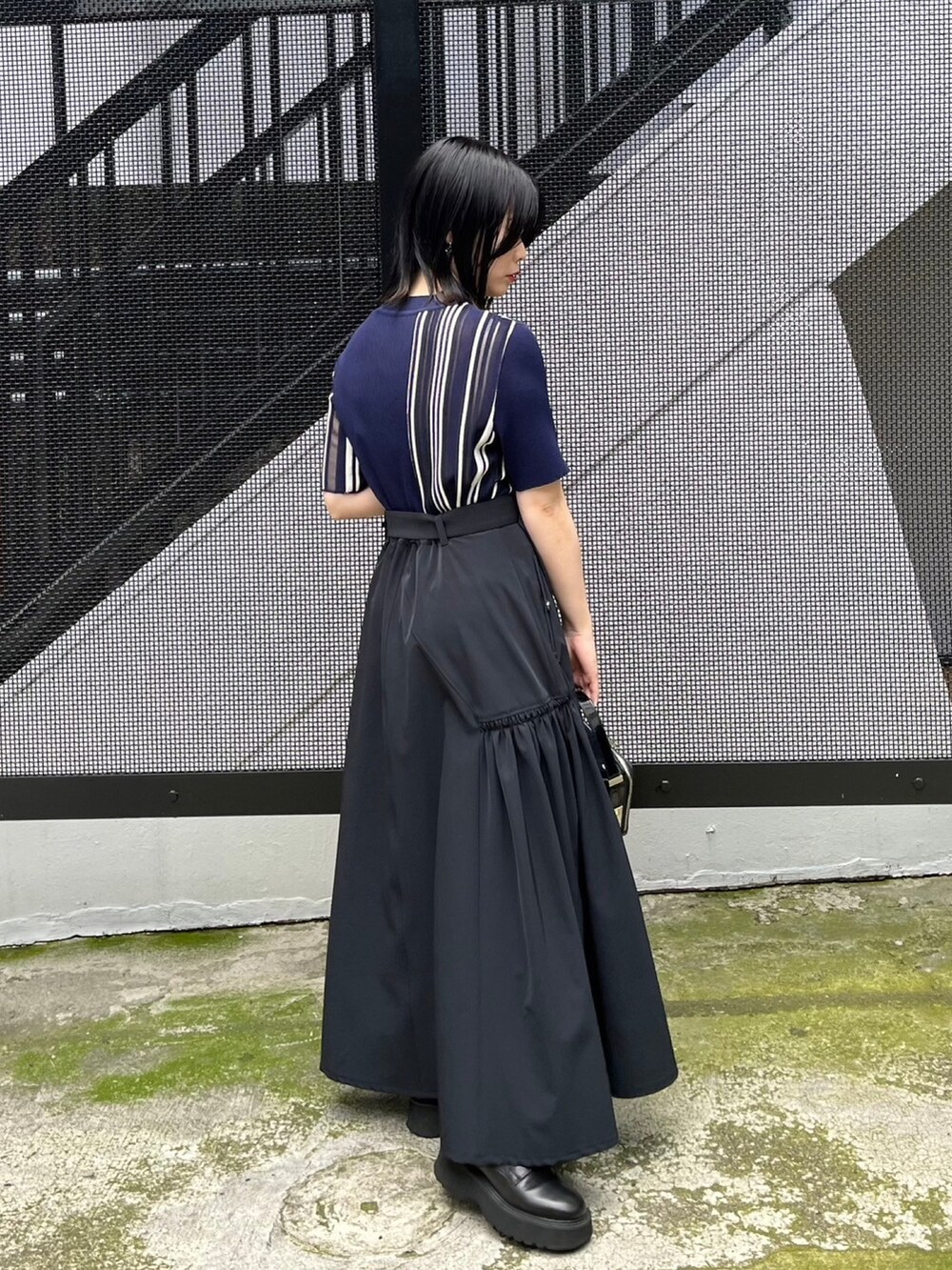 ブルー系のニット/セーター、ブラック系のスカートを着用したレディースの春コーディネートの3枚目の写真