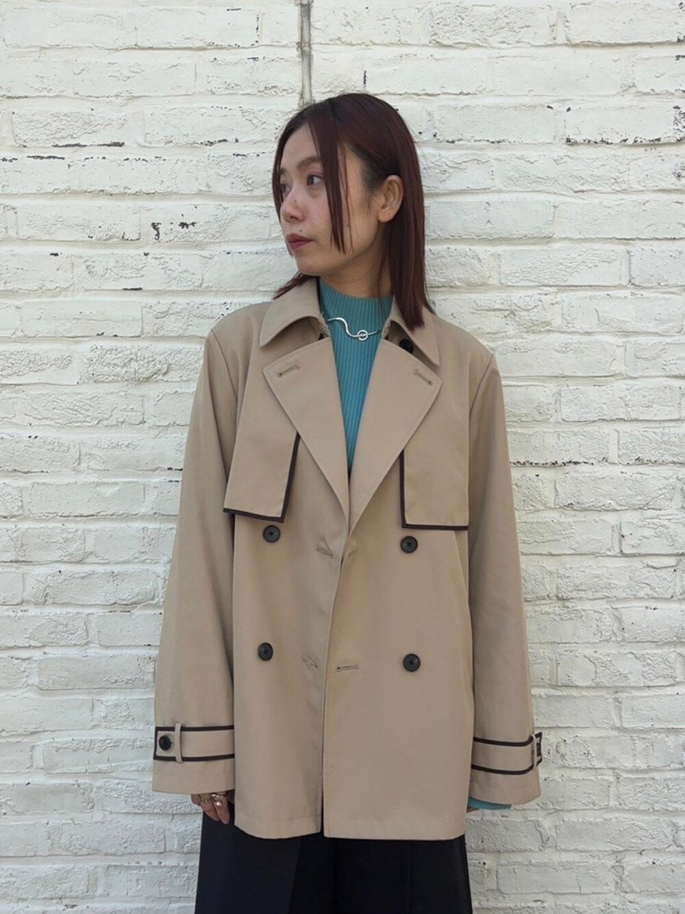 ベージュ系のトレンチコートを着用したレディースの春コーディネートの5枚目の写真