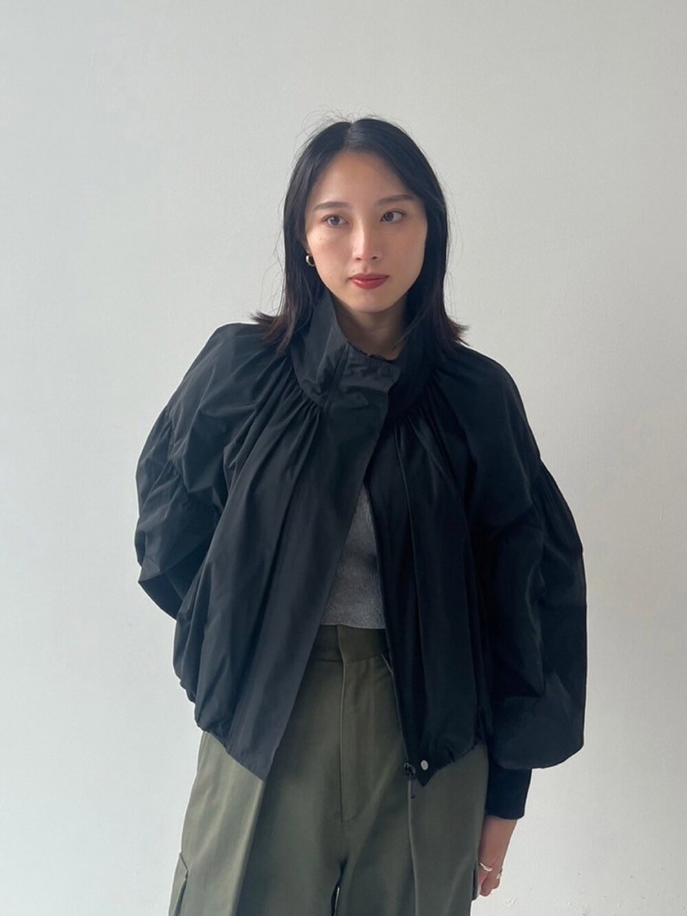 ブラック系のブルゾン、グリーン系のカーゴパンツを着用したレディースの秋コーディネートの3枚目の写真