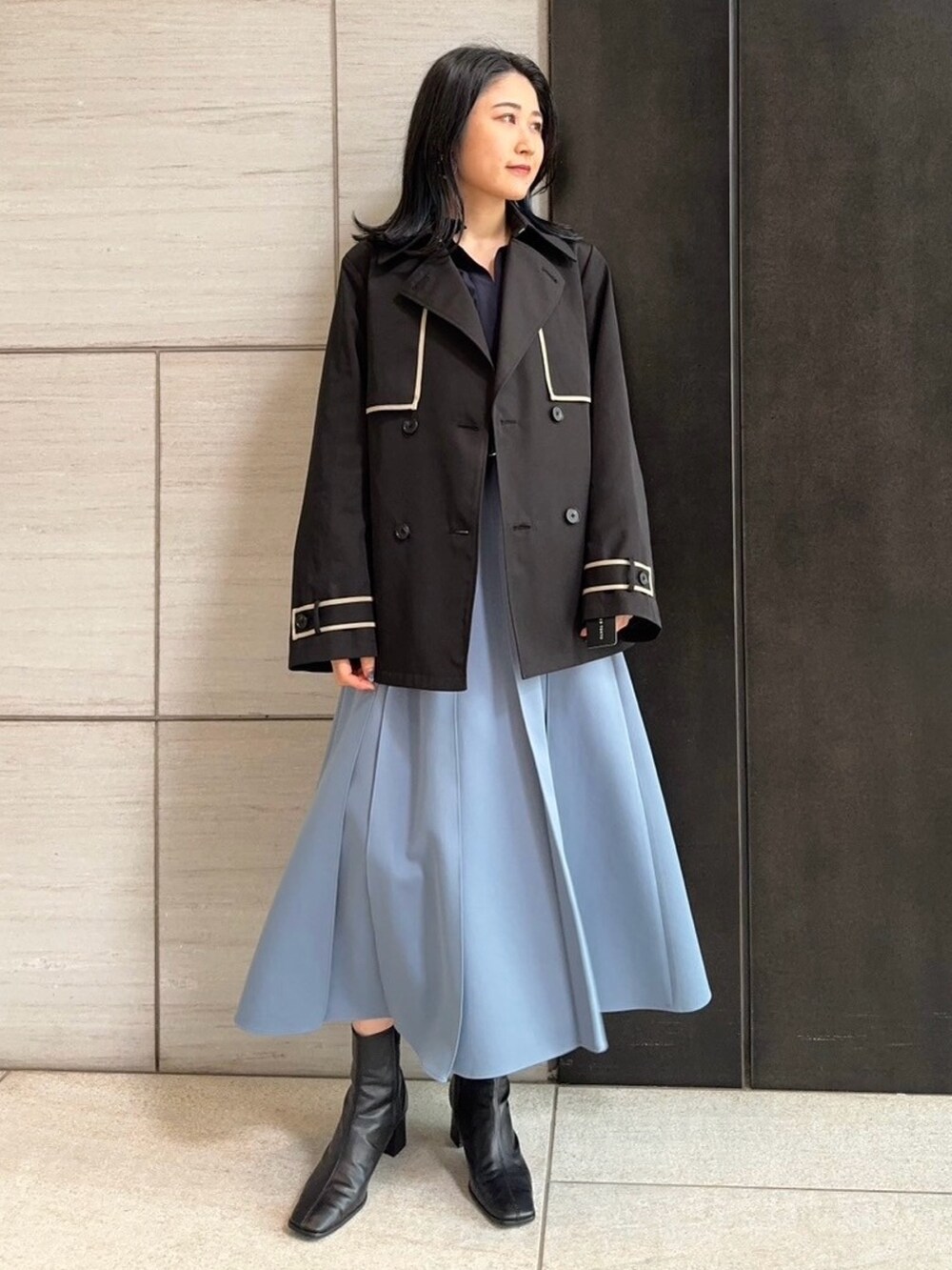 ブラック系のトレンチコートを着用したレディースの春コーディネートの8枚目の写真