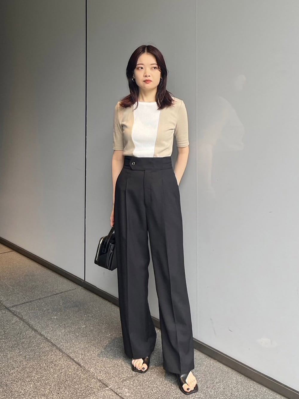 ベージュ系のTシャツ/カットソー、ブラック系のスラックスを着用したレディースの夏コーディネートの2枚目の写真