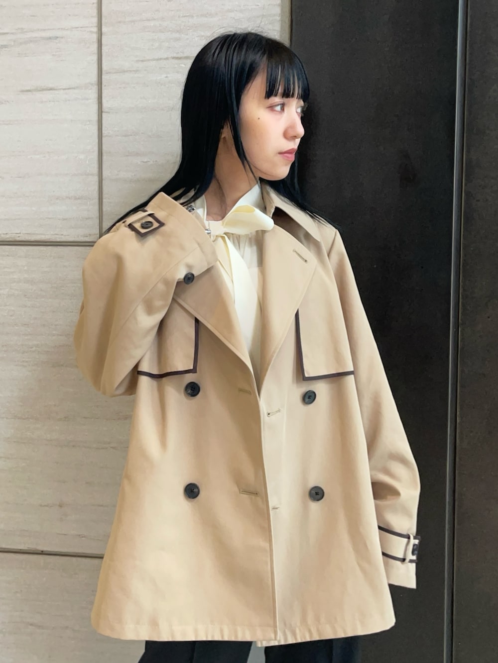 ベージュ系のトレンチコートを着用したレディースの春コーディネートの3枚目の写真