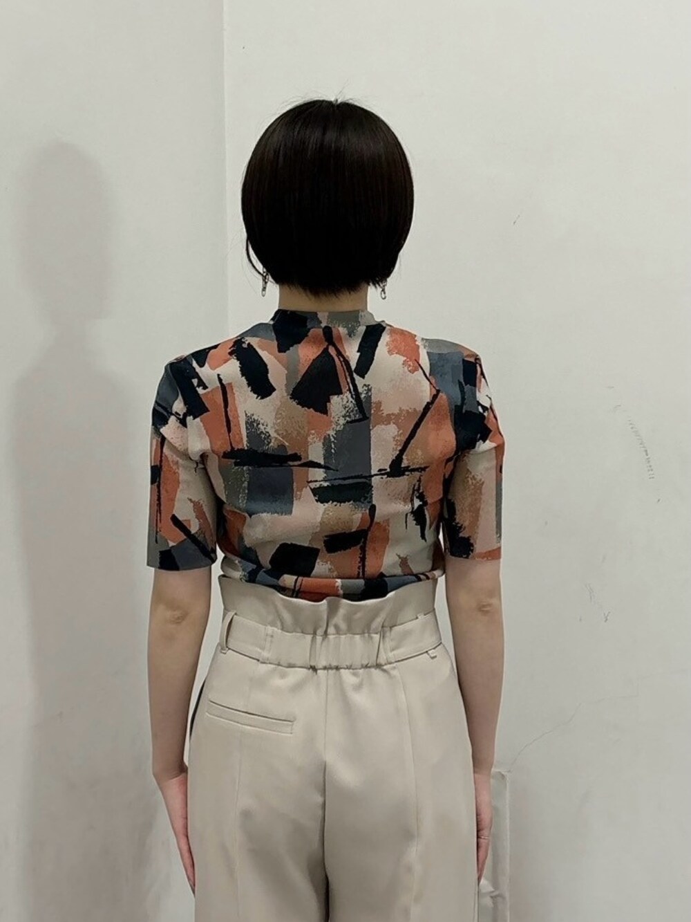 ベージュ系のTシャツ/カットソー、ベージュ系のスラックスを着用したレディースの春コーディネートの6枚目の写真