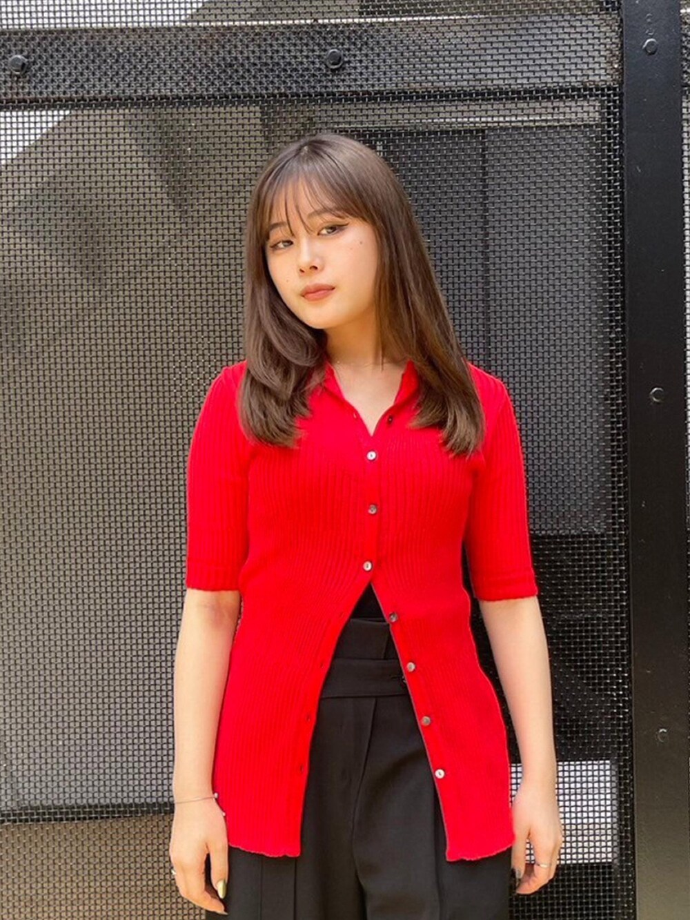 ブラック系のスラックス、レッド系のニット/セーターを着用したレディースの春コーディネートの4枚目の写真