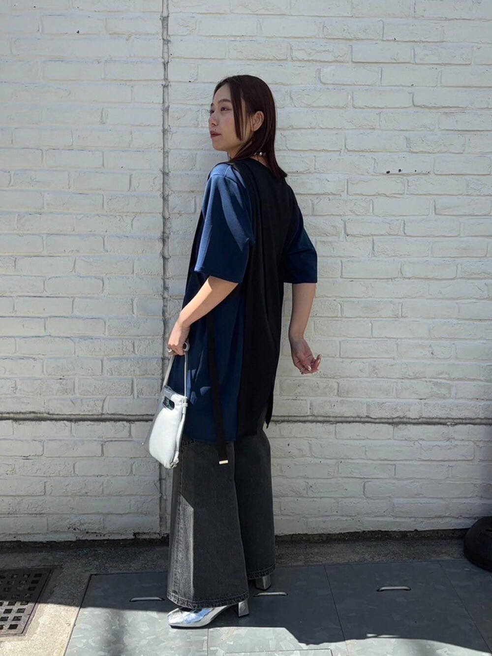 ブラック系のTシャツ/カットソー、ブラック系のデニムパンツを着用したレディースの春コーディネートの2枚目の写真