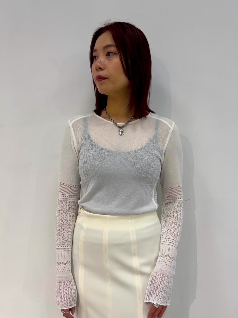 ホワイト系のニット/セーター、ホワイト系のスカートを着用したレディースの春コーディネートの5枚目の写真