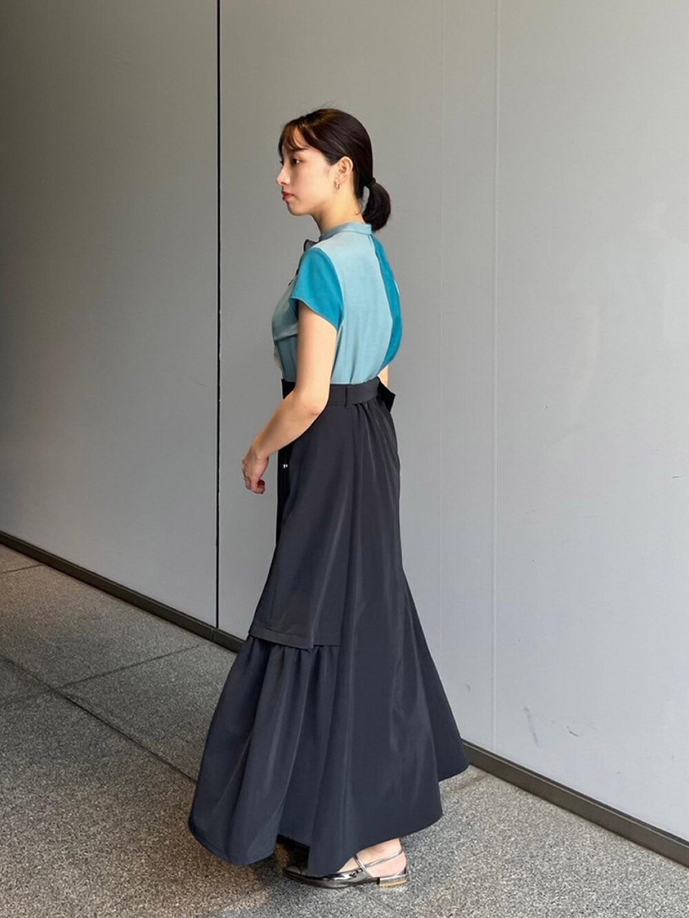 グリーン系のシャツ/ブラウス、ブラック系のスカートを着用したレディースの夏コーディネートの2枚目の写真