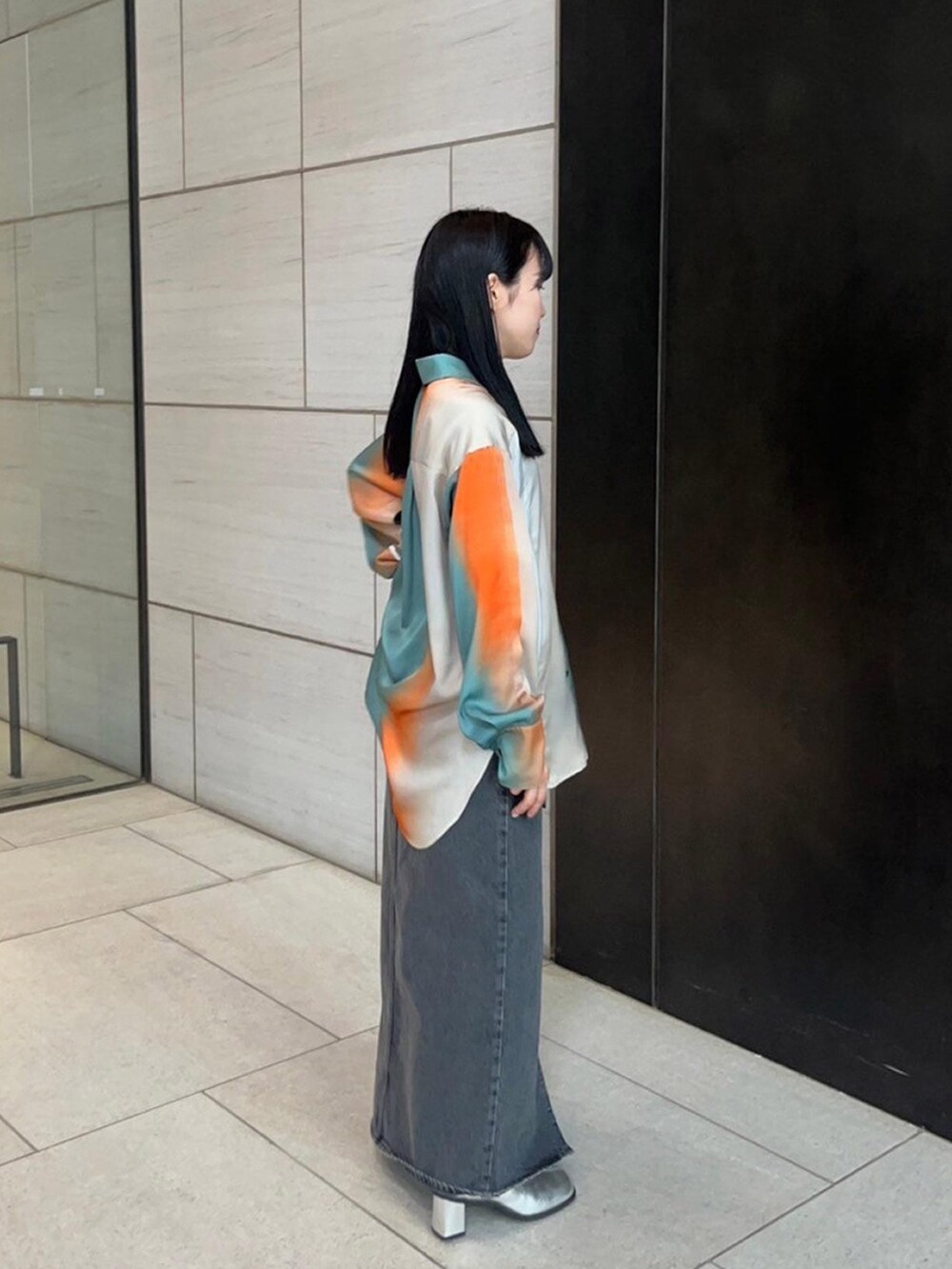 グリーン系のシャツ/ブラウス、ブラック系のデニムスカートを着用したレディースの春コーディネートの4枚目の写真