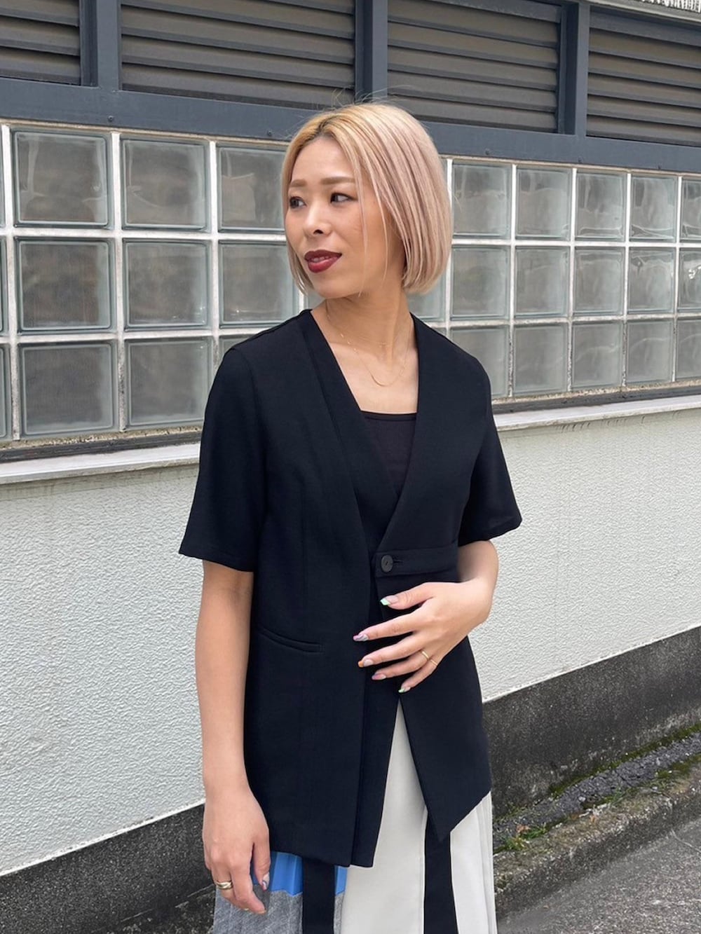 ブラック系のノーカラージャケット、ブルー系のスカートを着用したレディースの春コーディネートの6枚目の写真