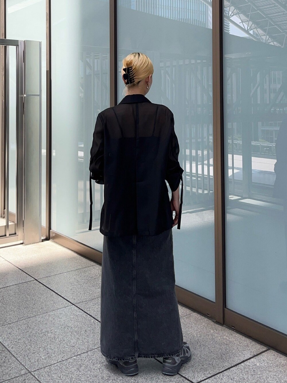 ブラック系のテーラードジャケット、ブラック系のデニムスカートを着用したレディースの夏コーディネートの3枚目の写真