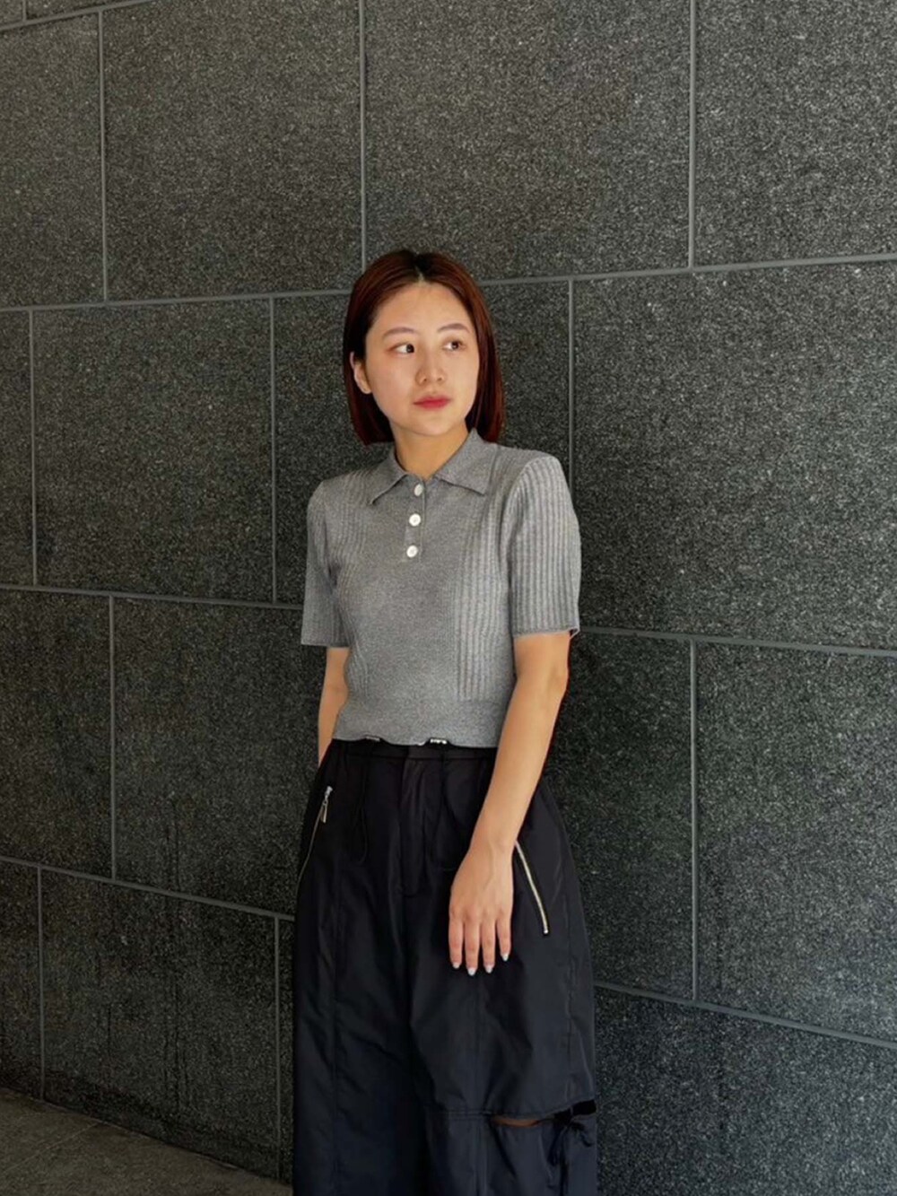 グレー系のポロシャツ、ブラック系のその他パンツを着用したレディースの夏コーディネートの4枚目の写真