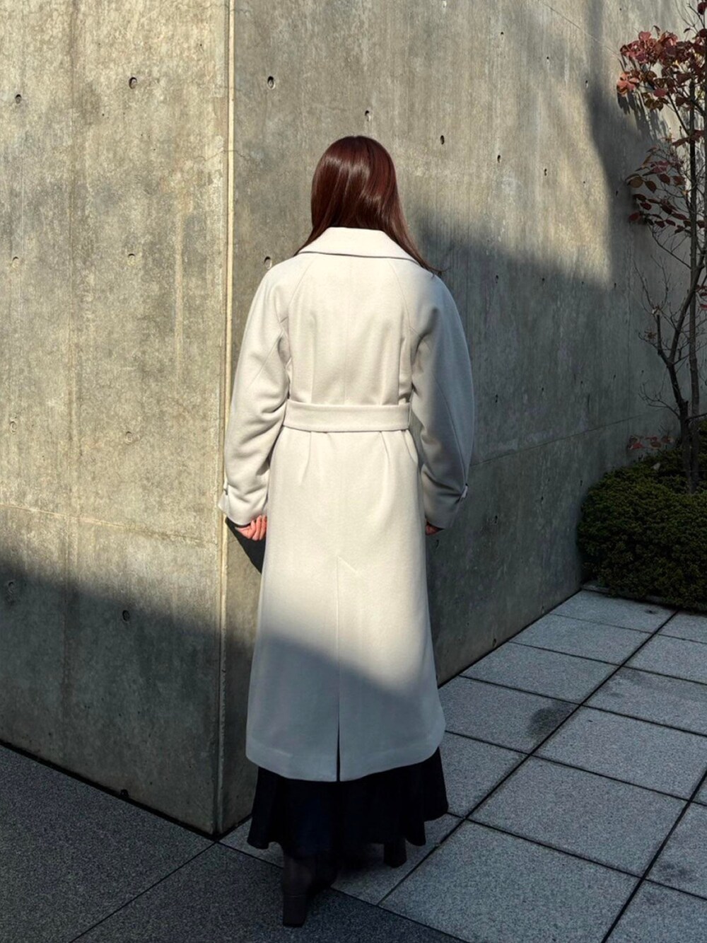 ホワイト系のステンカラーコートを着用したレディースの秋コーディネートの5枚目の写真