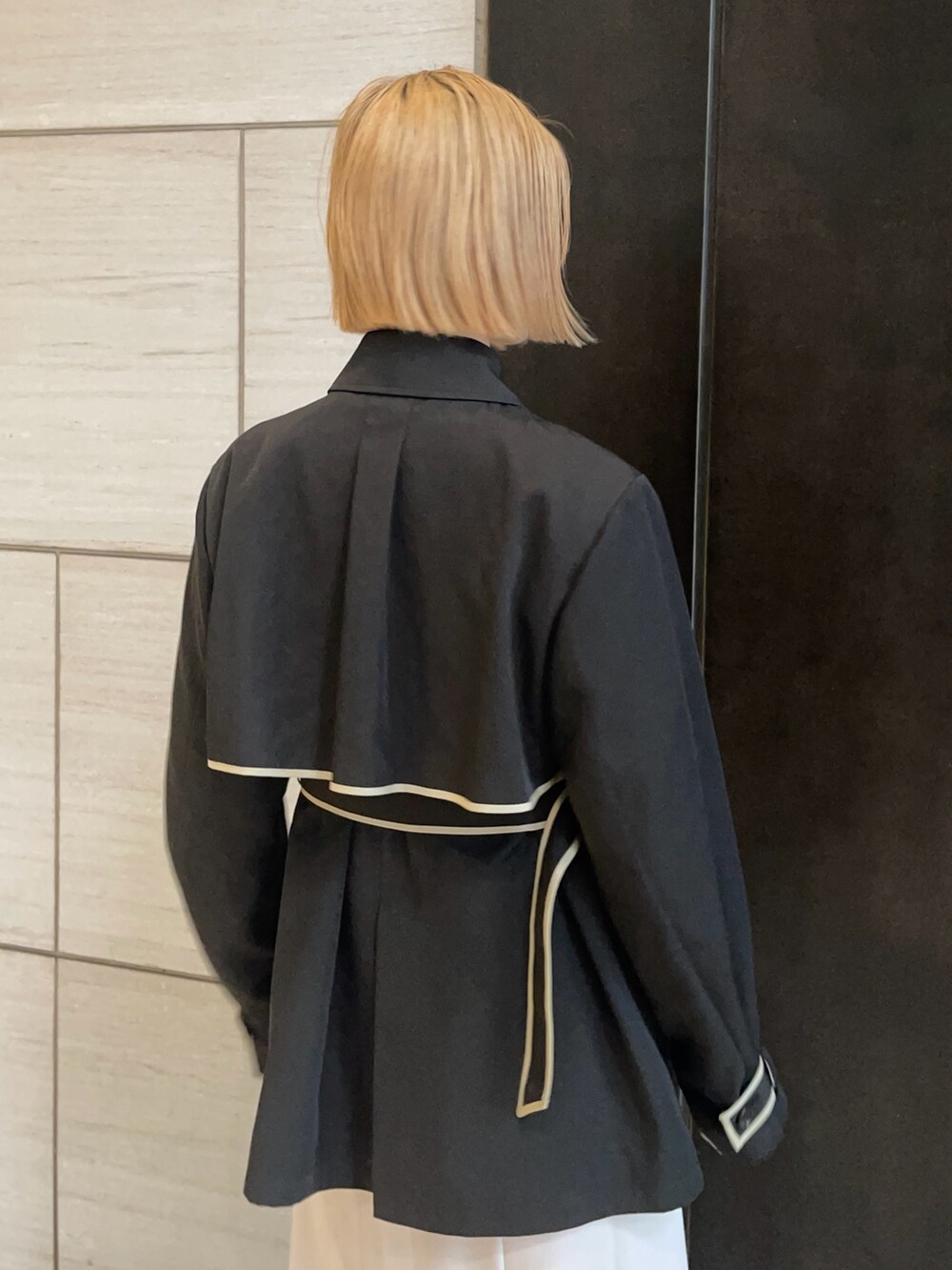 ブラック系のトレンチコートを着用したレディースの春コーディネートの6枚目の写真