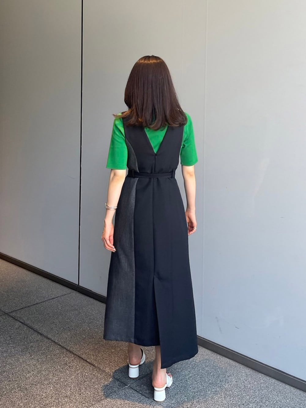 グリーン系のニット/セーター、ブラック系のジャンパースカートを着用したレディースの夏コーディネートの2枚目の写真