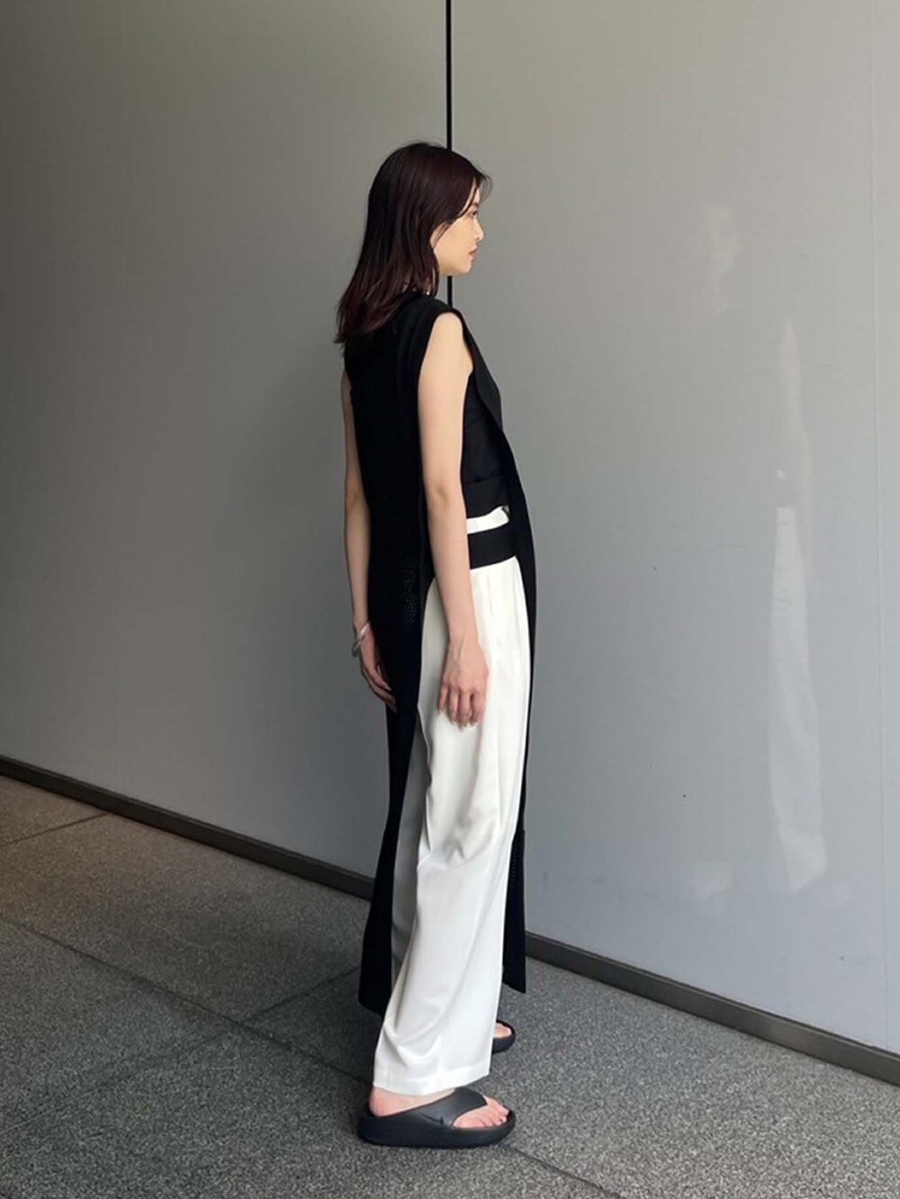 ブラック系のワンピース、ホワイト系のスラックスを着用したレディースの夏コーディネートの3枚目の写真