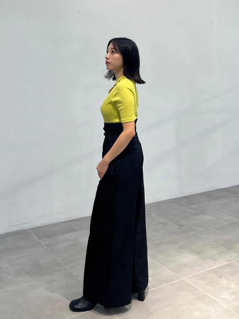 グリーン系のTシャツ/カットソー、ブラック系のスラックスを着用したレディースの秋コーディネートの2枚目の写真