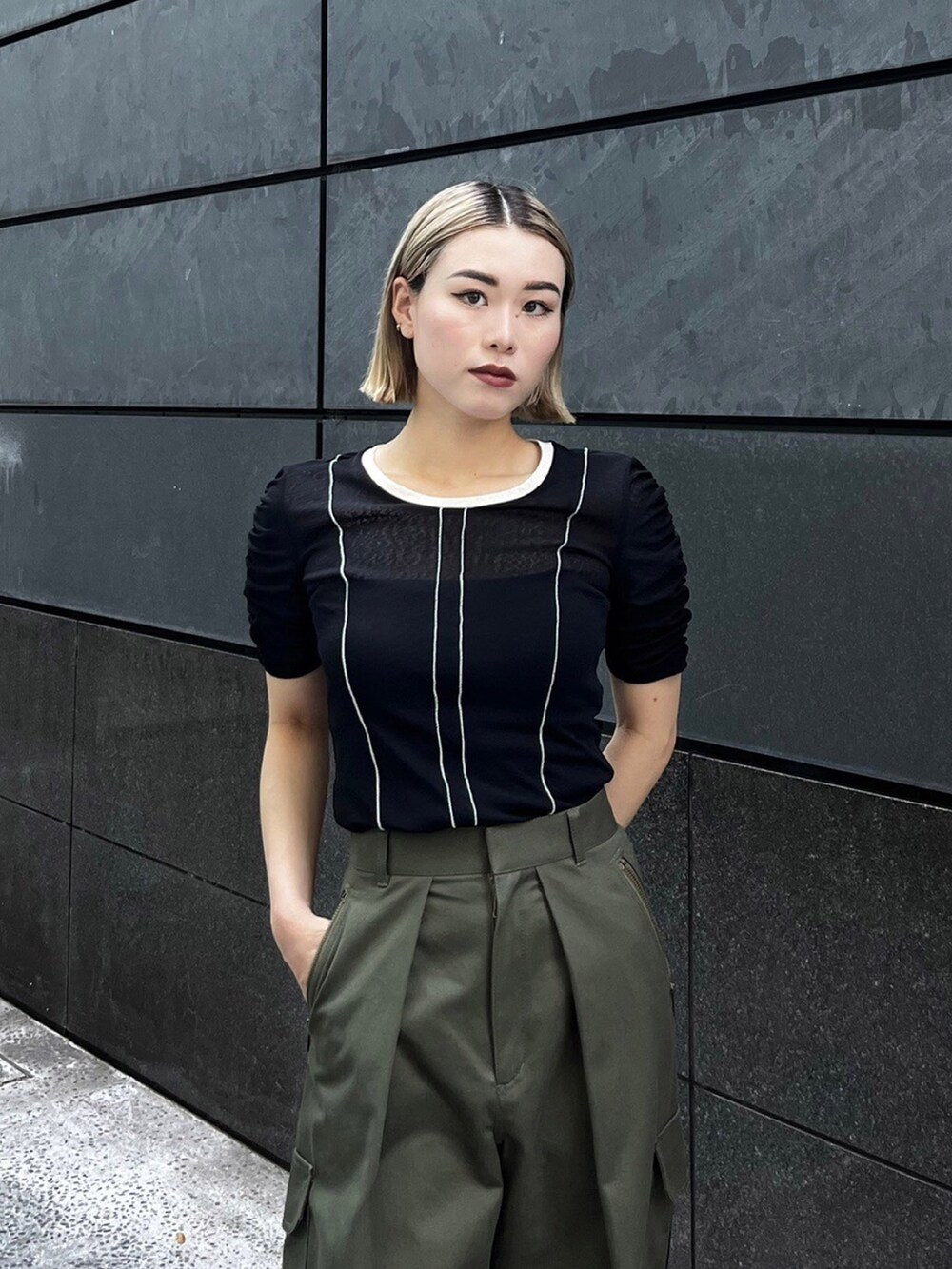 ブラック系のTシャツ/カットソー、グリーン系のカーゴパンツを着用したレディースの夏コーディネートの4枚目の写真