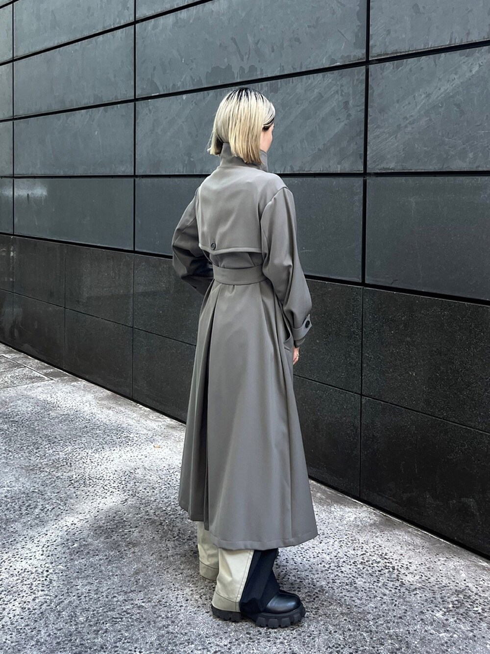 グレー系のトレンチコートを着用したレディースの秋コーディネートの2枚目の写真