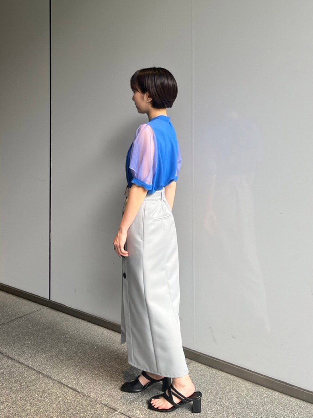 ブルー系のシャツ/ブラウス、グレー系のスカートを着用したレディースの夏コーディネートの2枚目の写真